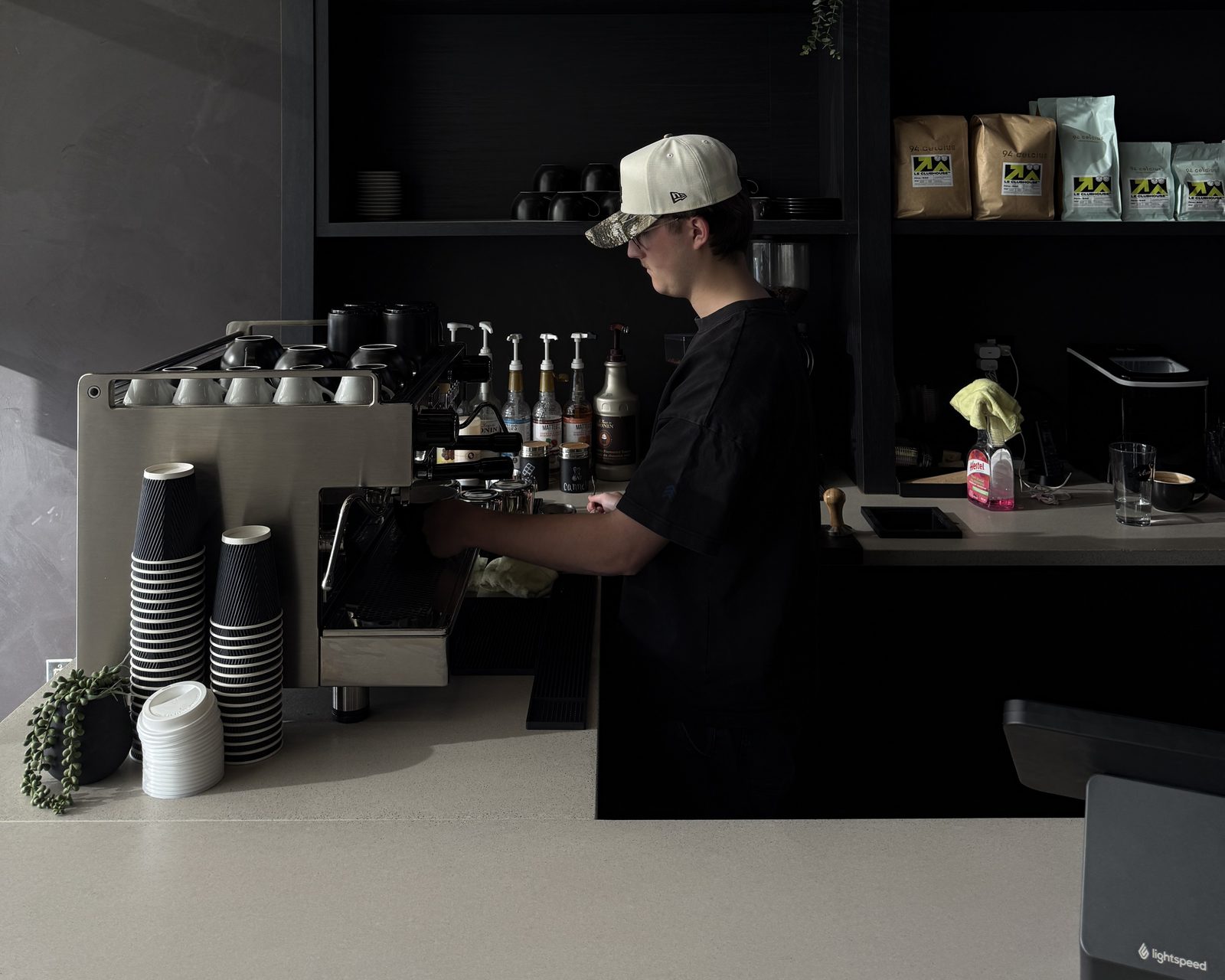 Le barista prépare un espresso à la machine Rocket Boxer à 2 groupes, devant les sacs de café Le Clubhouse